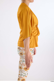 Hanane  1 arm flexing side view yellow loose knotted…